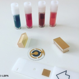 4 tubes colorés sur une table blanche